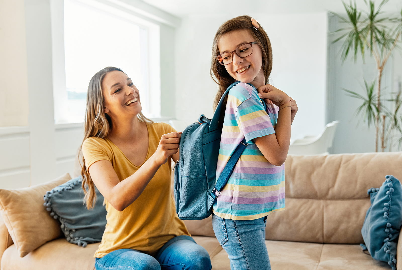 Mother zipping up daughter's backpack