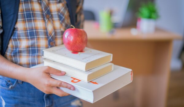 Red apple on top of 3 white books in Alvin ISD