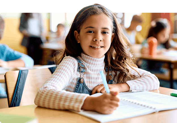 Young girl at desk with notebook and pen