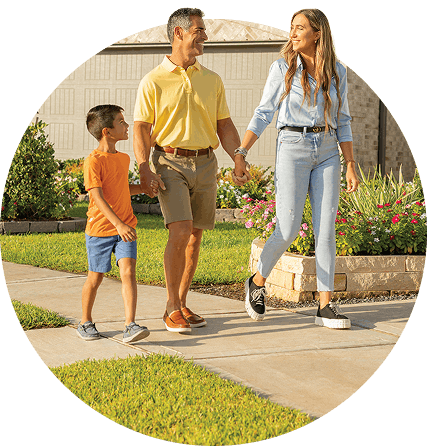 Mother Father and Child holding hands on the sidewalk at Creekhaven in Iowa Colony, TX